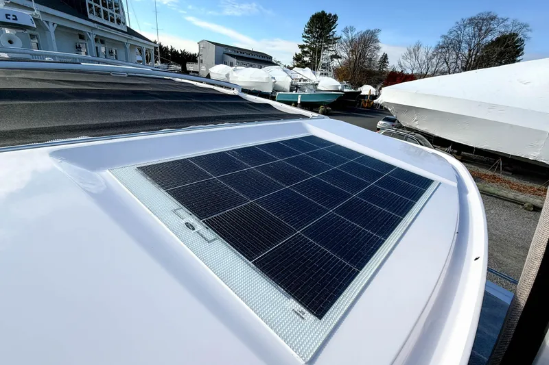 Slide: The Image of 2024 Axopar 45 XC Cross Cabin with solar panel on roof, docked in marina. - 44