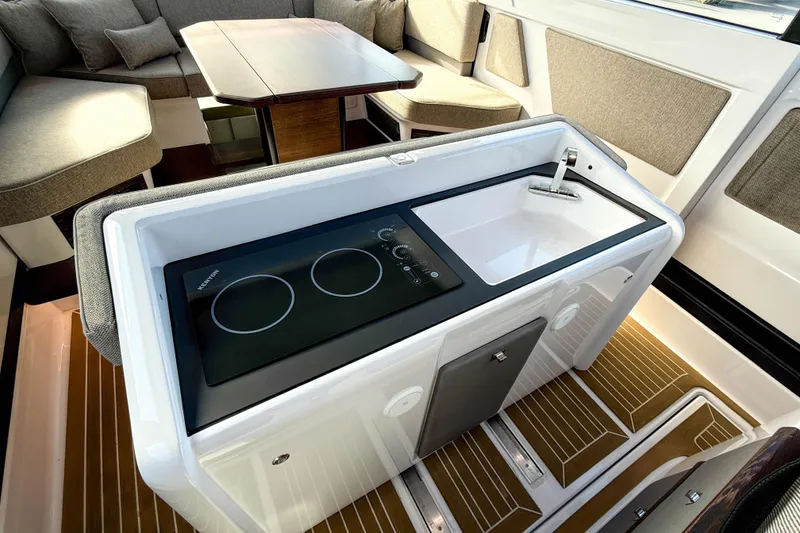 Slide: The Image of 2024 Axopar 45 XC Cross Cabin interior with modern kitchenette and seating area. - 9
