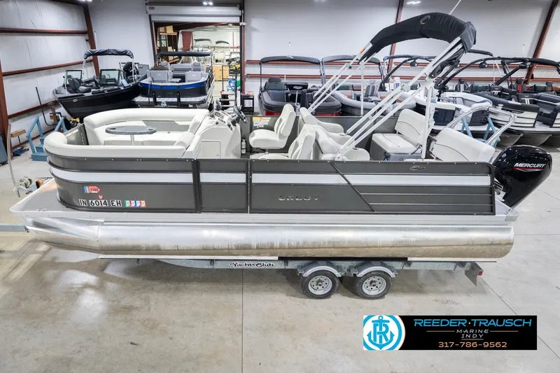 Slide: The Image of 2021 Crest SLRC 220 pontoon boat in showroom, featuring Mercury outboard motor. - 1