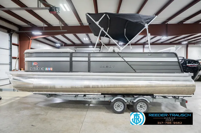 Slide: The Image of 2021 Crest SLRC 220 pontoon boat in indoor showroom, featuring a sleek design. - 10