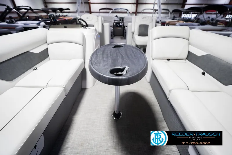 Slide: The Image of Interior of 2021 Crest SLRC 220 boat with seating and table, Reeder-Trausch Marine logo. - 15