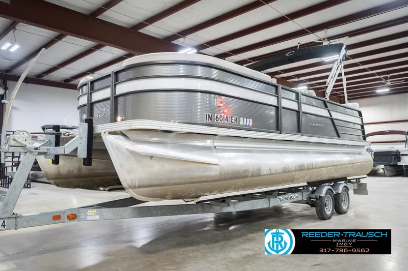 Slide: The Image of 2021 Crest SLRC 220 pontoon boat on trailer in indoor storage facility. - 2