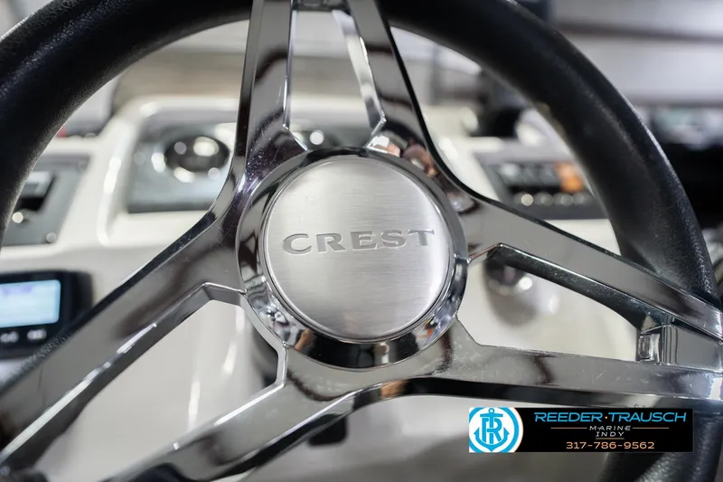 Slide: The Image of Steering wheel of 2021 Crest SLRC 220 boat, featuring chrome accents and logo. - 37