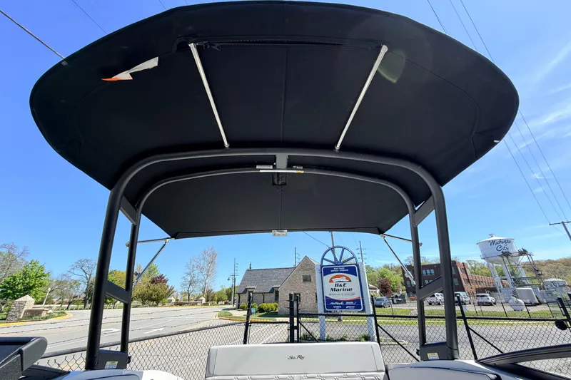 Slide: The Image of 2026 Sea Ray SPX 210 boat with canopy, parked near B&E Marine sign. - 21