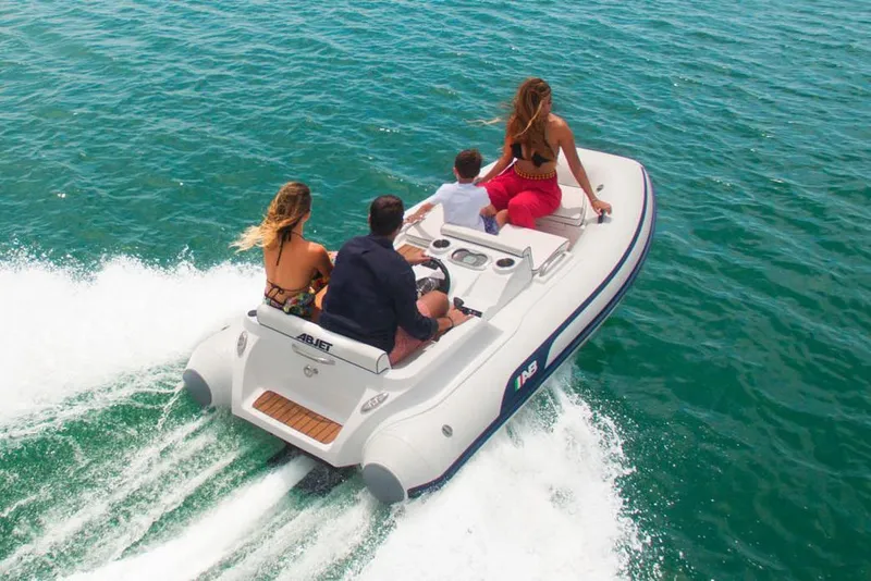The Image of 2026 AB Inflatables ABJET 330 boat displayed in showroom with Tender Care Boats logo. - 0
