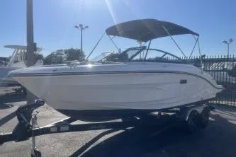 Slide: The Image of 2024 Sea Ray SPX 210 Outboard boat with canopy on trailer, parked outdoors. - 3