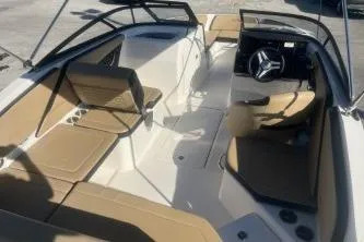 Slide: The Image of 2024 Sea Ray SPX 210 Outboard boat interior with tan seating and steering wheel. - 7
