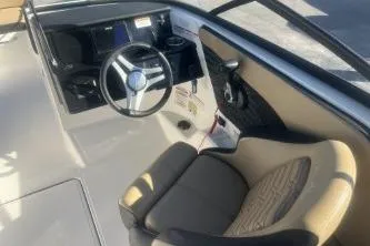 Slide: The Image of 2024 Sea Ray SPX 210 Outboard boat interior with steering wheel and seating. - 8