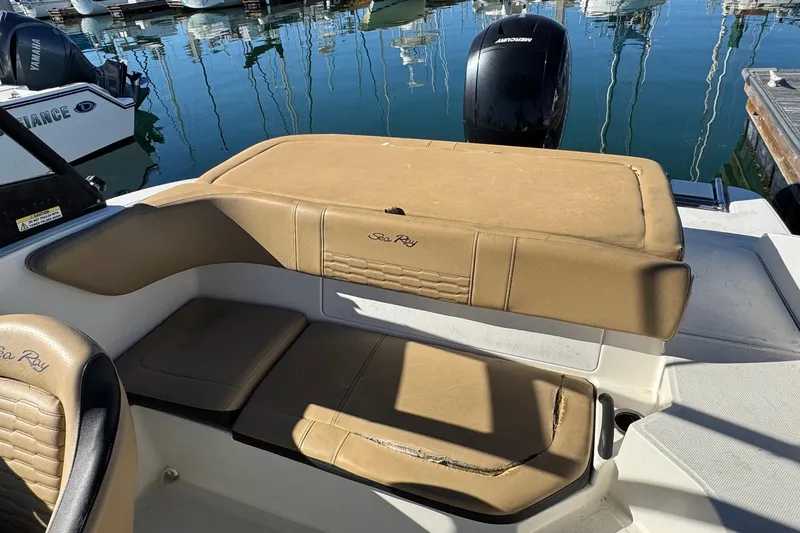 Slide: The Image of 2022 Sea Ray SPX 190 Outboard boat interior with tan seating, docked at marina. - 24