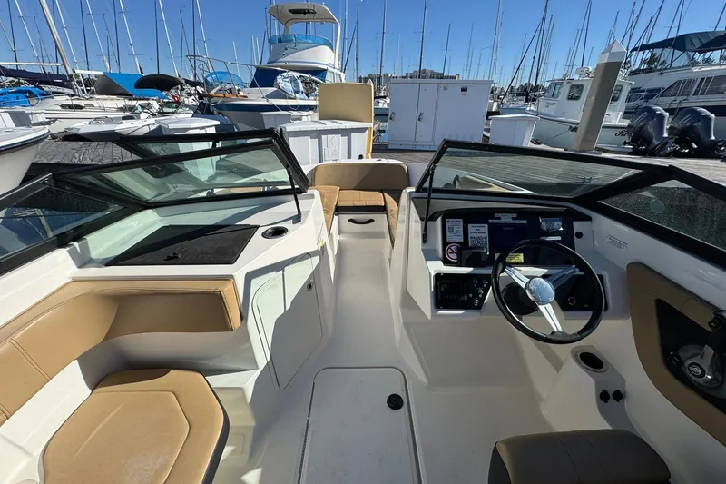 Slide: The Image of 2022 Sea Ray SPX 190 Outboard boat interior at marina, featuring steering wheel and seating. - 34