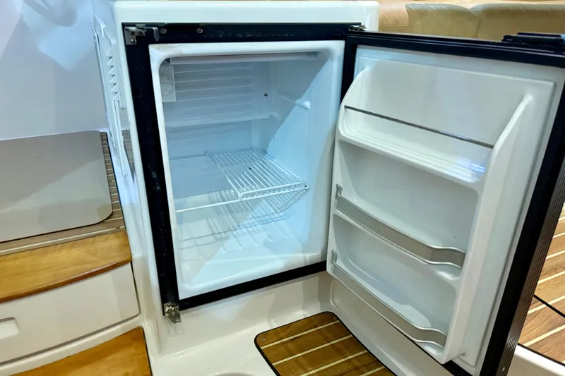 Slide: The Image of Open refrigerator on 2011 Back Cove 37 boat, showcasing interior shelves and door compartments. - 11
