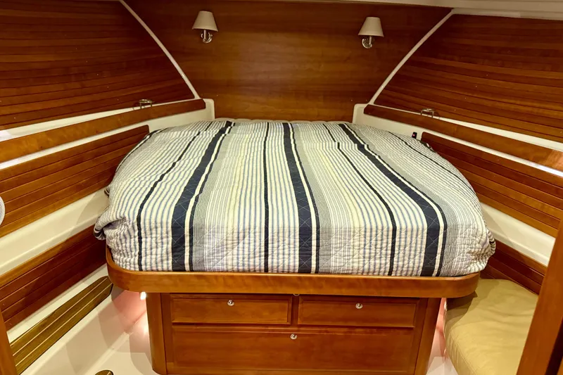Slide: The Image of Luxurious cabin interior of 2011 Back Cove 37 yacht with striped bedding and wooden accents. - 16