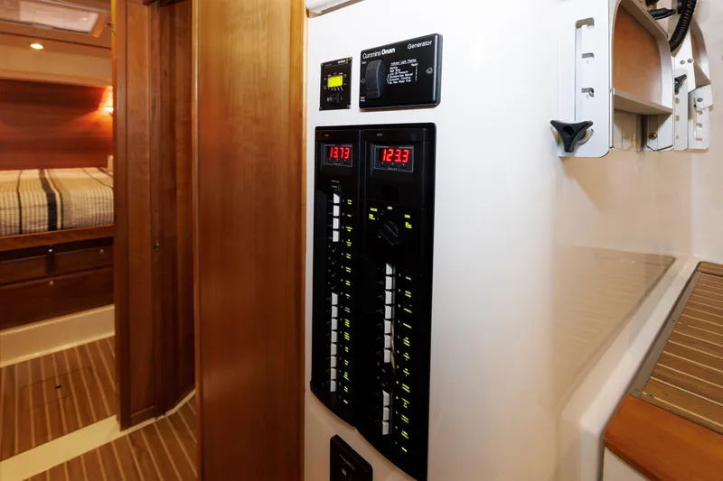 Slide: The Image of Electrical panel inside 2011 Back Cove 37 yacht, featuring control switches and digital displays. - 24
