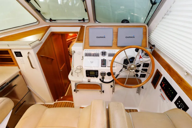 Slide: The Image of Helm of 2011 Back Cove 37 boat with Garmin navigation, wooden accents, and steering wheel. - 29