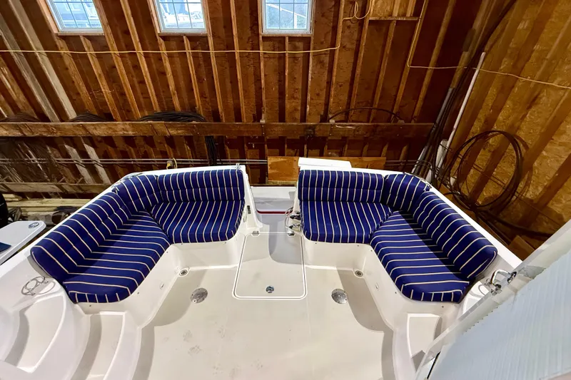 Slide: The Image of 2011 Back Cove 37 boat interior with blue striped seating in a wooden boathouse. - 3