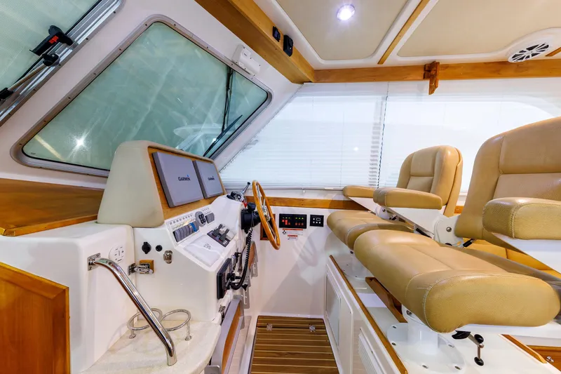 Slide: The Image of Interior helm of 2011 Back Cove 37 boat with beige seating and navigation equipment. - 35
