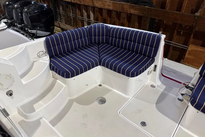 Slide: The Image of Blue-striped seating on 2011 Back Cove 37 boat deck, featuring white steps and outboard motors. - 4