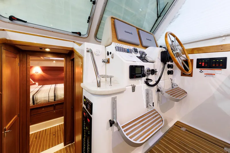 Slide: The Image of 2011 Back Cove 37 helm station with wooden accents and cabin view. - 41