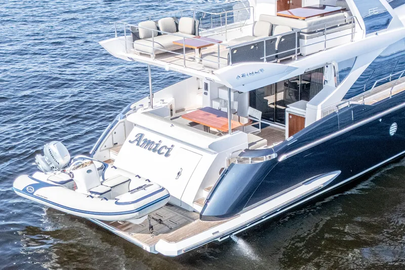 Slide: The Image of 2017 Azimut 66 Flybridge yacht on water, featuring spacious deck and tender boat. - 5