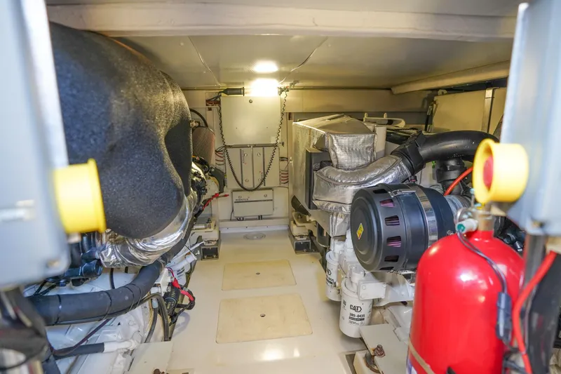 Slide: The Image of Engine room of 2017 Azimut 66 Flybridge yacht, featuring mechanical components and fire extinguisher. - 68