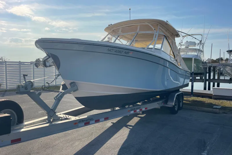 Slide: The Image of 2023 Grady-White Freedom 285 boat on trailer at marina under clear sky. - 2