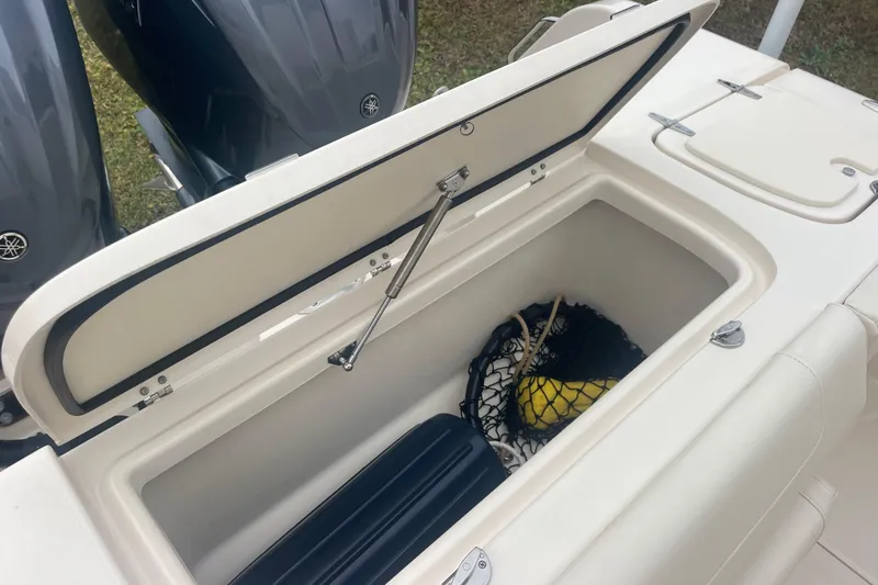 Slide: The Image of Open storage compartment on 2023 Grady-White Freedom 285 boat with fishing gear inside. - 23