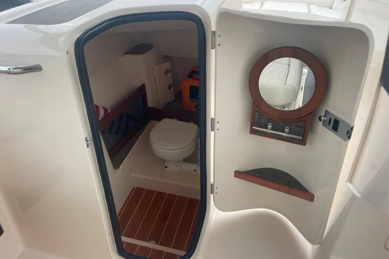 Slide: The Image of 2023 Grady-White Freedom 285 boat interior with compact bathroom and wooden accents. - 31