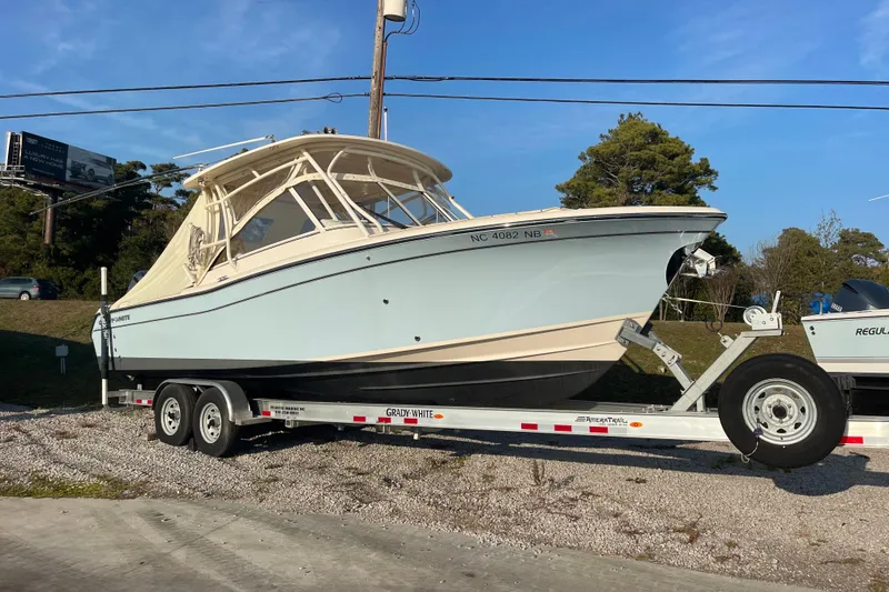 Slide: The Image of 2023 Grady-White Freedom 285 boat on trailer, parked outdoors under clear sky. - 4