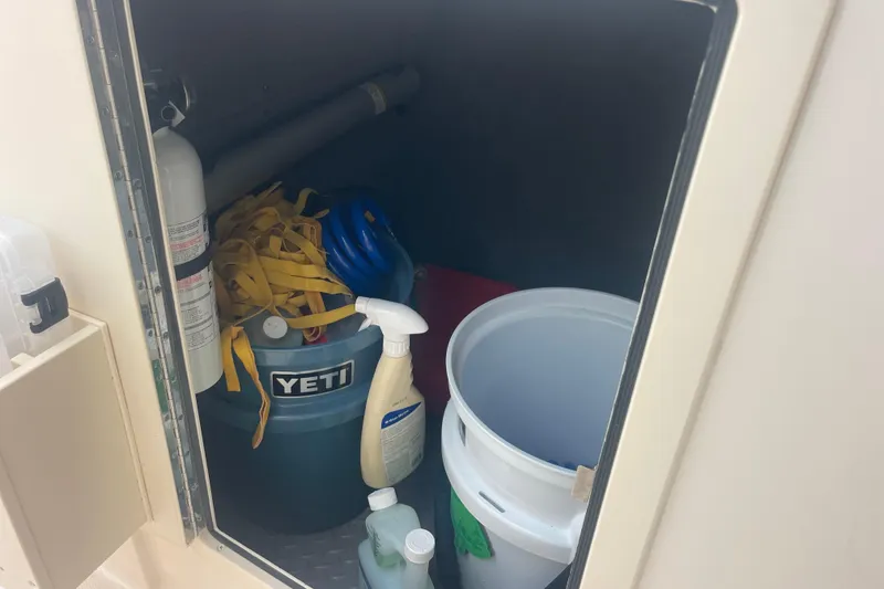Slide: The Image of Storage compartment in 2023 Grady-White Freedom 285 boat with cleaning supplies and equipment. - 47