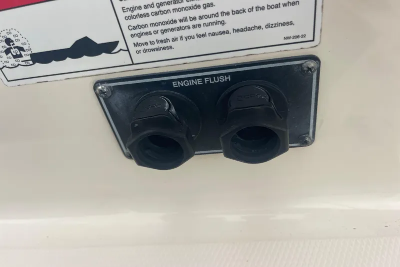 Slide: The Image of 2023 Grady-White Freedom 285 engine flush ports with safety warning label. - 62