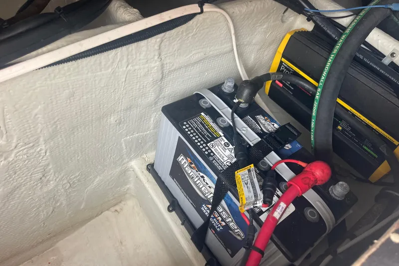 Slide: The Image of Battery compartment of 2023 Grady-White Freedom 285 boat, featuring marine battery and wiring. - 66