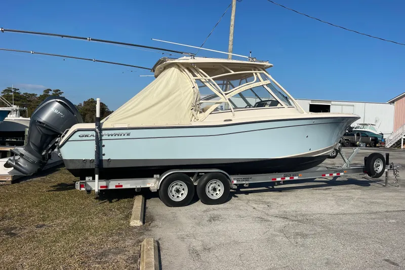 Slide: The Image of 2023 Grady-White Freedom 285 boat on trailer, parked outdoors under clear blue sky. - 9