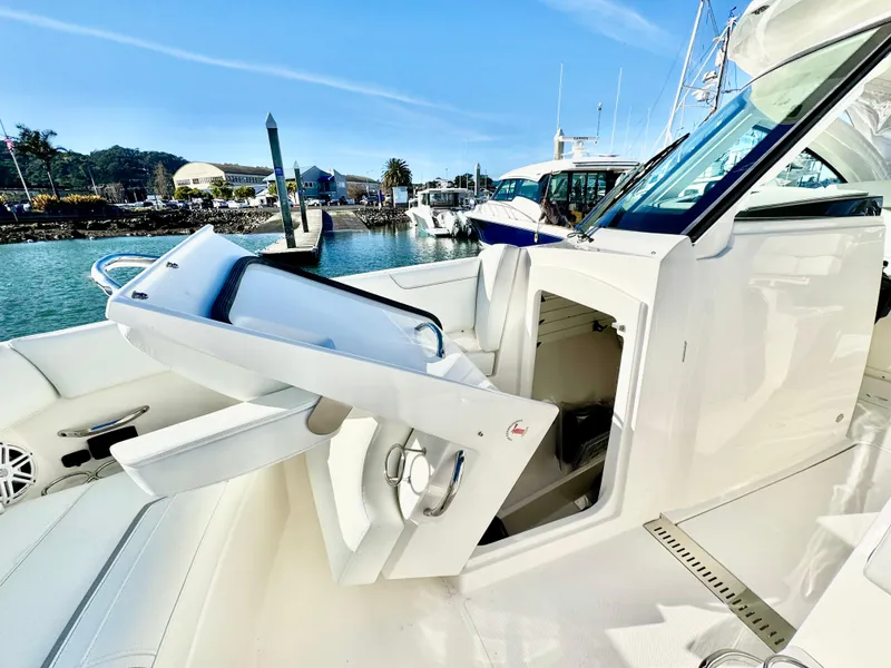 Slide: The Image of 2025 Tiara Yachts 34 LX luxury yacht interior with open hatch, docked at marina. - 19