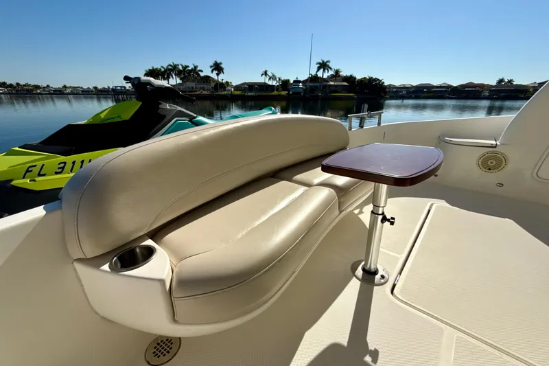 Slide: The Image of 2009 Meridian 391 Sedan boat with beige seating and small table, docked near a jet ski. - 34