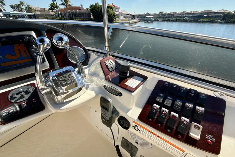 Slide: The Image of 2009 Meridian 391 Sedan helm with controls and navigation system, overlooking waterfront homes. - 45