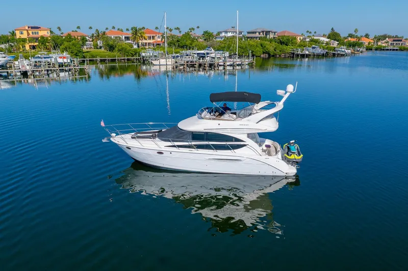 Slide: The Image of 2009 Meridian 391 Sedan yacht on calm water, surrounded by waterfront homes and docks. - 57