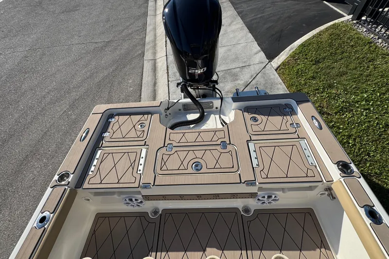 Slide: The Image of 2019 Key West 230 Bay Reef boat deck with storage compartments and outboard motor. - 100