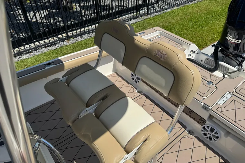 Slide: The Image of 2019 Key West 230 Bay Reef boat interior with cushioned seating and outboard motor. - 142