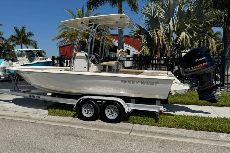 Slide: The Image of 2019 Key West 230 Bay Reef boat on trailer, parked near palm trees. - 3