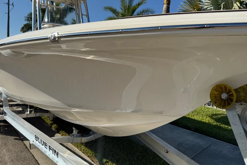 Slide: The Image of 2019 Key West 230 Bay Reef boat on trailer, side view with palm trees. - 31
