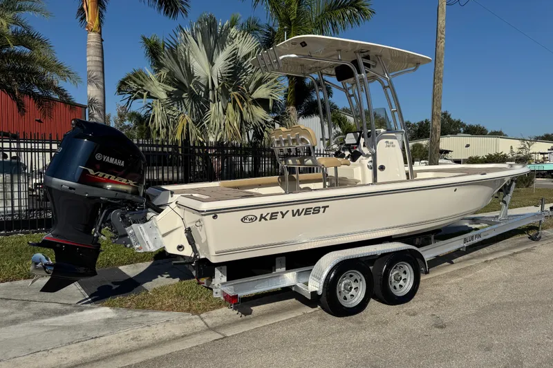 Slide: The Image of 2019 Key West 230 Bay Reef boat on trailer with Yamaha engine, parked near palm trees. - 7