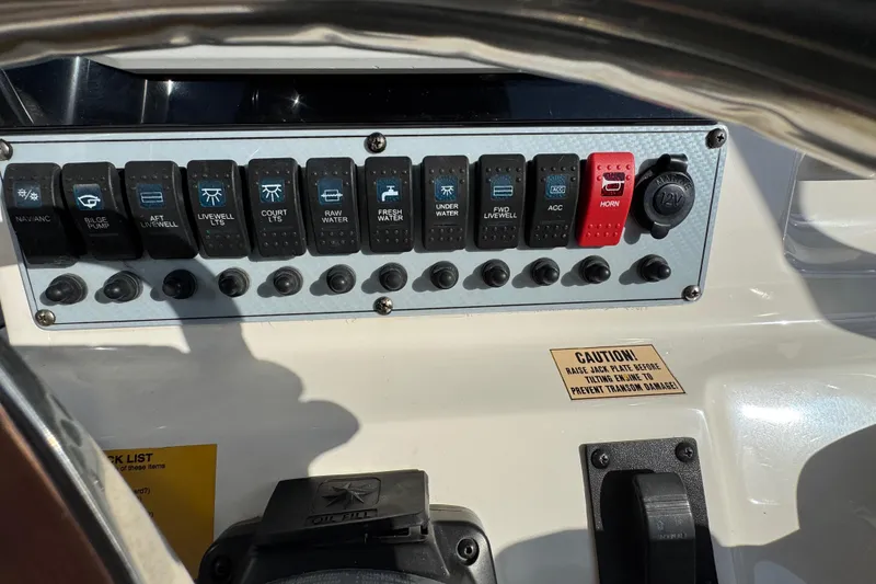 Slide: The Image of Control panel of a 2019 Key West 230 Bay Reef boat with labeled switches. - 92