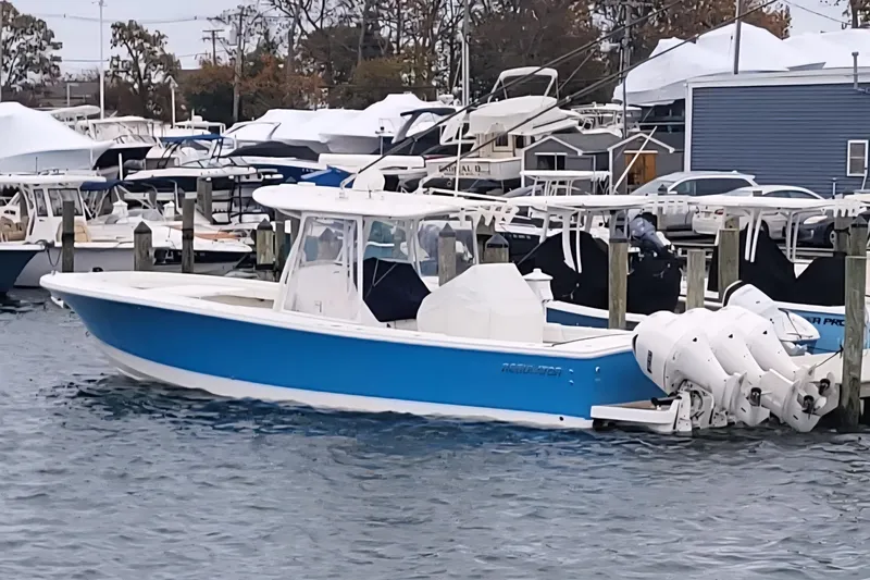 Slide: The Image of 2019 Regulator 34SS boat with blue hull on a calm waterway. - 1
