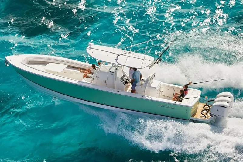 Slide: The Image of 2019 Regulator 34SS boat interior with rod holders and blue canopy under clear sky. - 10