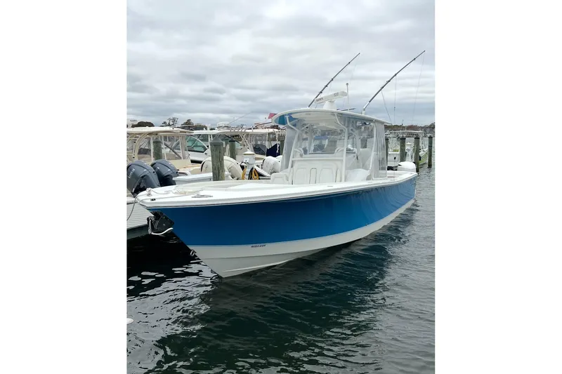 Slide: The Image of 2019 Regulator 34SS boat cruising on a calm waterway under a partly cloudy sky. - 2