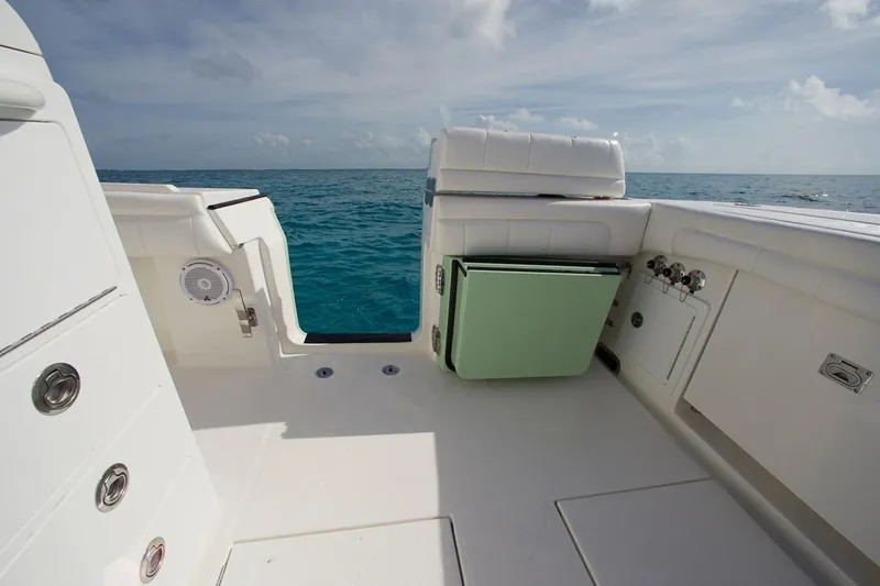 Slide: The Image of 2019 Regulator 34SS boat interior with seating and table, docked beside another vessel. - 29