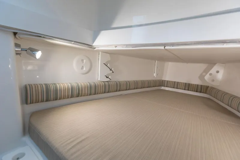 Slide: The Image of 2019 Regulator 34SS boat with white seating and clear canopy, docked at marina. - 30