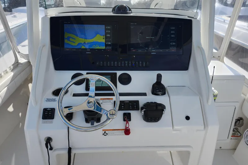 Slide: The Image of 2019 Regulator 34SS boat on water, blue hull, white deck, clear sky background. - 4