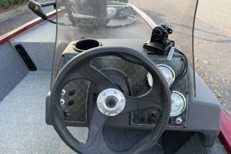 Slide: The Image of 2020 Tracker Pro 160 boat dashboard with steering wheel and gauges. - 2