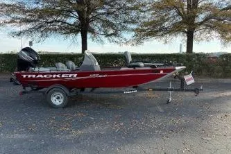 Slide: The Image of 2020 Tracker Pro 160 boat on trailer, parked outdoors with trees in background. - 3